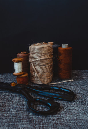 retro sewing tools: old scissors, bobbins of thread on gray fabric. Tailor's desk. manufacture of textiles or fine fabrics.の写真素材