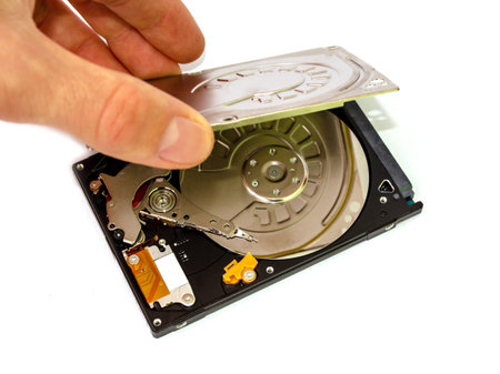 the repairer opens the top cover of the hard drive with his hand HDD