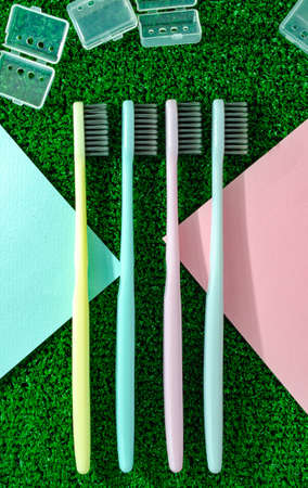 clean colorful toothbrushes on green grassの写真素材