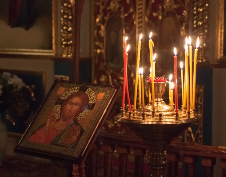 GOMEL - MAY 4: Interior of Belarusian orthodox church in Easte. Candles under the ancient icon framed with the gold on May 4, 2013 in Gomel, Belarusのeditorial素材