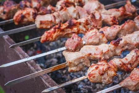 Juicy slices of meat with sauce prepare on fire (shish kebab).の写真素材
