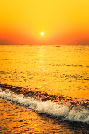 Soft sea ocean waves wash over golden sand background. Sunset, sunrise, sunの写真素材