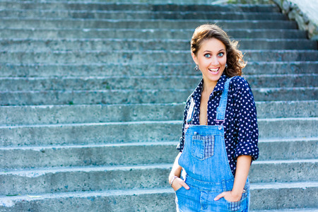 Summer beautiful girl portrait. Pretty young caucasian happy woman standing on staircase.の写真素材