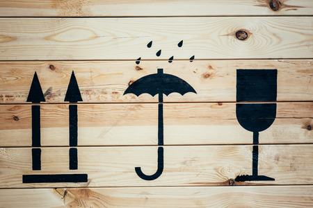 Wooden background and fragile symbol on packageの写真素材