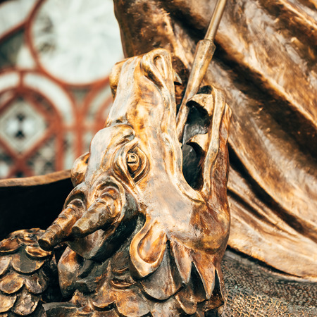 Close Up Detail Of Statue Of Archangel Michael With Outstretched Wings, Thrusting Spear Into Dragon Before Red Catholic Church Of St. Simon And St. Helena On Independence Square In Minsk, Belarusの写真素材
