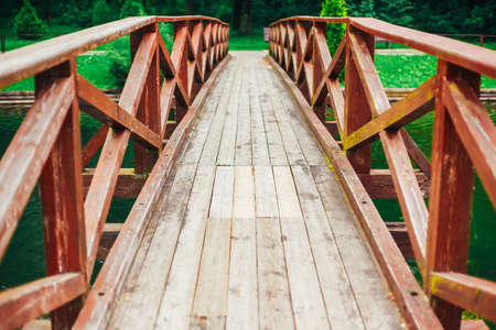 Old Red Rustic Wooden Bridge Over Pond Background.の写真素材