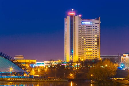 MINSK, BELARUS - MARCH 10, 2015: Hotel Building "Belarus" In Old Part Minsk, Downtown Nyamiha, Nemiga View With Svisloch River, Belarus. Night Scene Streetのeditorial素材