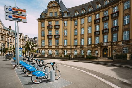 LUXEMBOURG, LUXEMBOURG - JUNE 17, 2015: Row of city bikes for rent on a background of bank building Banque et Caisse d'Epargne de l'Etatのeditorial素材