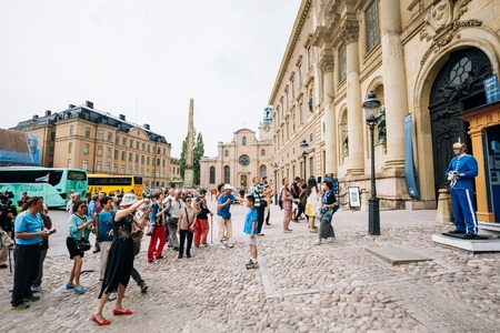 STOCKHOLM, SWEDEN - JULY 30, 2014: Tourists visit and photograph the guard of honor at the Royal palace in Gamla Stan, where king Carl XVI Gustaf has his working office.のeditorial素材
