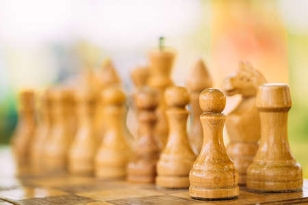 White Old Chess Standing On Wooden Chessboardの写真素材