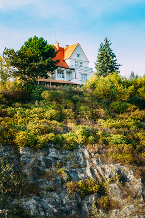 Red wooden house cottage on top of cliff or rock, summer sunny evening.の写真素材