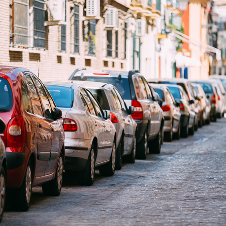 Cars parked on street in European city in sunny summer day.の写真素材