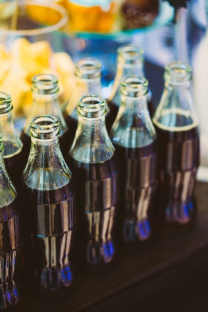 Refreshing Brown Soda in bottles in Candy Bar On Table. Delicious sweet buffet.の写真素材