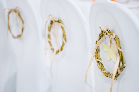 Decorative wreath on white chairs covered with cloth.の写真素材