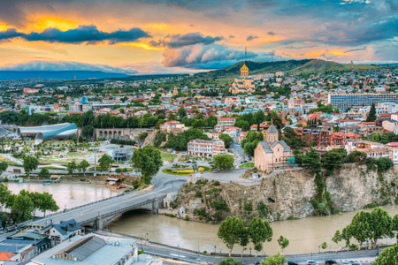 Evening View Of Tbilisi At Colorful Sunset, Georgia. Summer Cityscape. On Photograph Visible A New Concert Hall, Avlabar Residence - Presidential Administration Of Georgia, Holy Trinity Cathedral Of Tbilisi, Metekhi Churchの写真素材