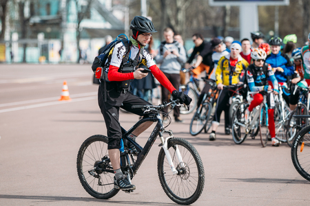 Gomel, Belarus - April 10, 2015: Young man cyclist in sportswear for cycling uses smartphone phone while drivingのeditorial素材