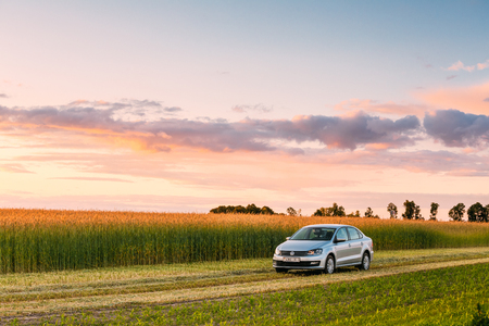 Gomel, Belarus - June 6, 2016: Volkswagen Polo Car Parking On Wheat Field. Sunset Sunrise Dramatic Sky On A Background In Sunny Evening.のeditorial素材