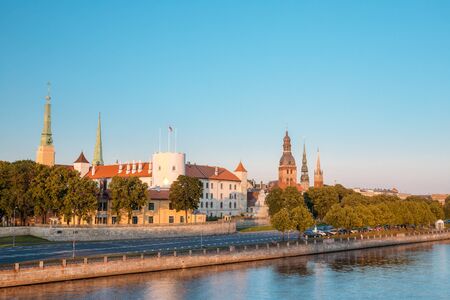 Scenic View To Promenad Of Daugava, In Riga, Latvia. Old Church Towers And Medieval Castle On Background. Seafront Named Ab Dambis. Evening  View With Blue Sky. Travel Destination. Urban Viewの写真素材