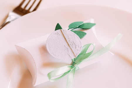 Wedding Candy-box Lies On A Plate. Bomboniere Also Known As Favors, Are Gifts Given By Hosts To Their Guests On Special Occasions Such As Bar And Bat Mitzvahs, Weddings Etc. Decoration For Wedding Celebration.の写真素材