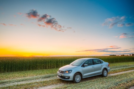 Gomel, Belarus - June 6, 2016: Volkswagen Polo Car Parking On Wheat Field. Sunset Sunrise Dramatic Sky On A Background In Sunny Evening.のeditorial素材