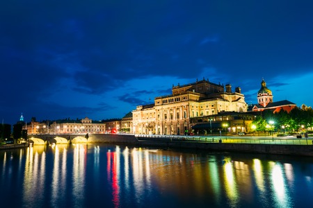 Stockholm, Sweden. The Scenic Night View Of Illuminated Royal Swedish Opera Theatre And Norrbro Arch Bridge Over Norrstrom Waterway With Lights Reflections In The Water Under Dramatic Blue Sky.の写真素材
