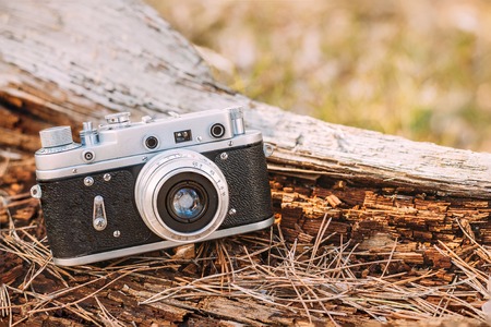 35mm Vintage Old Retro Small-Format Rangefinder Camera On Old Fallen Wood Tree In Forest.の写真素材