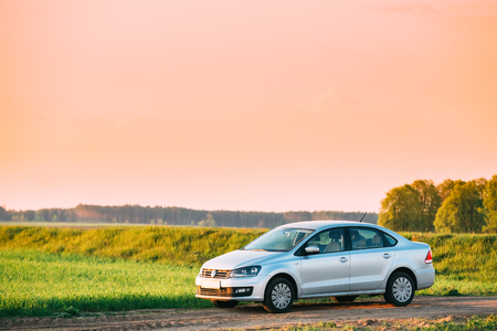 Gomel, Belarus - May 04, 2016: Volkswagen Polo Car Sedan Parking On Wheat Field. Sunset Sunrise Yellow Color Sky On A Background In Sunny Evening.のeditorial素材