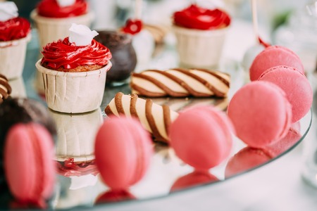 Dessert Sweet Tasty Cupcakes, Macarons And Cookies In Candy Bar On Table. Delicious Sweet Buffet. Wedding Holiday Decorationsの写真素材