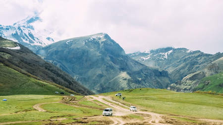 Cars SUV Go On Off Road From Gergeti Holy Trinity Church With Viewsの写真素材