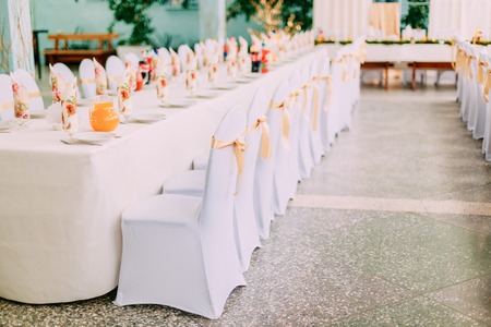 Decorative White Mantles And Colored Ribbons On Chairs At Festive Table.の写真素材