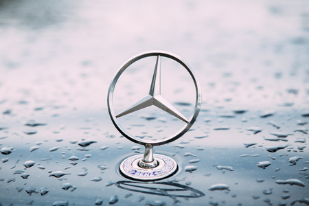 Close View Of Metal Star Logo Of Mercedes Benz At Wet Hood Of Blueのeditorial素材