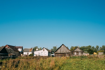 Old Russian Traditional Wooden Houses In Village Or Countryside Of Belarus Or Russia Countries. Sunny Blue Sky In Summer Day.の写真素材