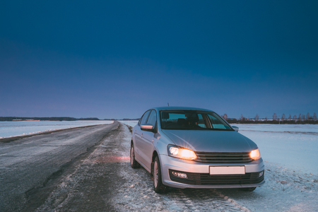 Car Sedan In Country Road At Winter Eveningの写真素材
