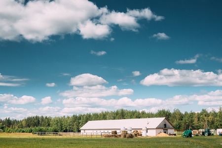 Countryside Rural Landscape With Farm Paddock For Horse, Shed Or Barn Or Stable With Haystacks In Lat Summer Season.の写真素材