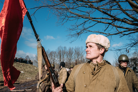Re-enactor Dressed As Russian Soviet Infantry Soldier Of World War II Holding Red Flagのeditorial素材