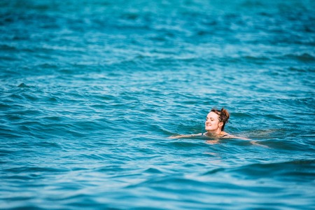 Caucasian Young Woman Swimming In Sea Oceanの写真素材