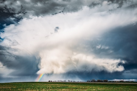 Rainbow In Countryside Rural Field Spring Meadow Landscape Under Scenic Dramatic Skyの写真素材