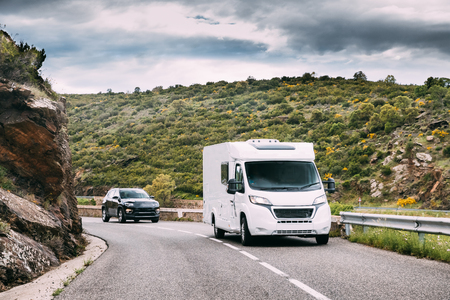 White Colour Motorhome Car Goes On Road On Background Of Spanish Mountain Nature Landscape. Catalonia, Spainの写真素材
