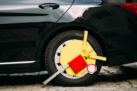 Wheel Of Car Was Locked With Yellow Clamped Wheel Lock By Traffic Policeの写真素材