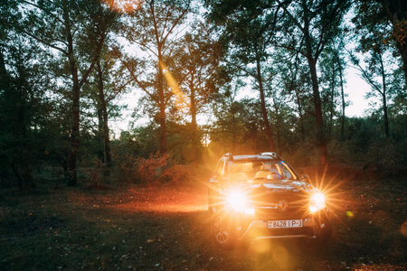 Car Renault Duster SUV in autumn evening forest. Duster produced