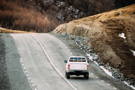 White SUV Car Moving On Mountain Road In Autumn Mountains Landscの写真素材
