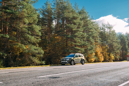 Car Renault Duster SUV is parked on side of road near autumn forのeditorial素材