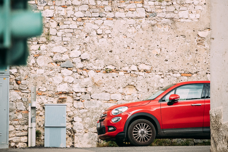 Terracina, Italy. Red Color Fiat 500X Car Parked On Background Old Wall.のeditorial素材