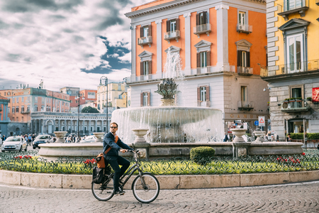 Naples, Italy. Adult Caucasian Man Tourist Riding On Bicycle Near Fontana del Carciofoのeditorial素材