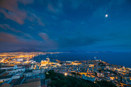 Naples, Italy. Skyline Cityscape In Evening Lighting. Tyrrhenian Sea And Landscape With Volcano Mount Vesuvius. City In Night Illuminationsの写真素材
