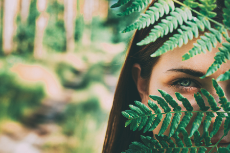 Portrait Of A Young Happy Beauty Red Hair Girl Woman Holding Fern Leaf Up To Face In Summer Park Forestの写真素材