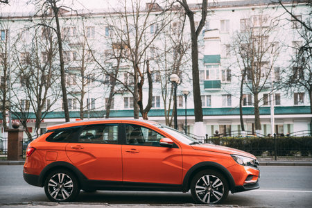 Gomel, Belarus - April 8, 2019: Orange Lada Vesta SW Cross Car Parked At Street. Side Viewのeditorial素材