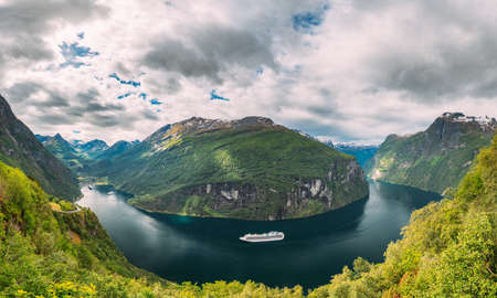 Geirangerfjord, Norway - June 19, 2019: Touristic Ship Ferry Boat Cruise Ship Liner Floating Near Geiranger In Geirangerfjorden. Famous Norwegian Landmark And Popular Destination. Panorama.のeditorial素材