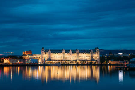 Oslo, Norway - June 25, 2019: Night View Embankment And Residential Multi-storey House On Langkaia Street In City Center In Oslo, Norway. Summer Evening. Residential Area Reflected In Sea Waters.のeditorial素材