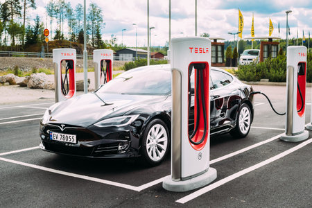 Black Color Tesla Model S 100d Car Parked At Charging Station. The Tesla Model S Is A Full-sized...